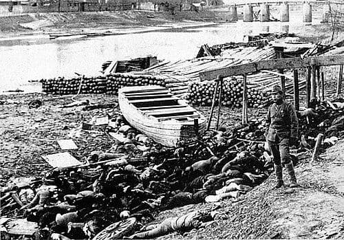 1937年12月,南京,遇难者遗体陈列于河岸,一名日本士兵立于前景。照片由日本士兵村瀬守保拍摄,他曾参与中国战线的军事行动,战后将随军照片整理出版。
