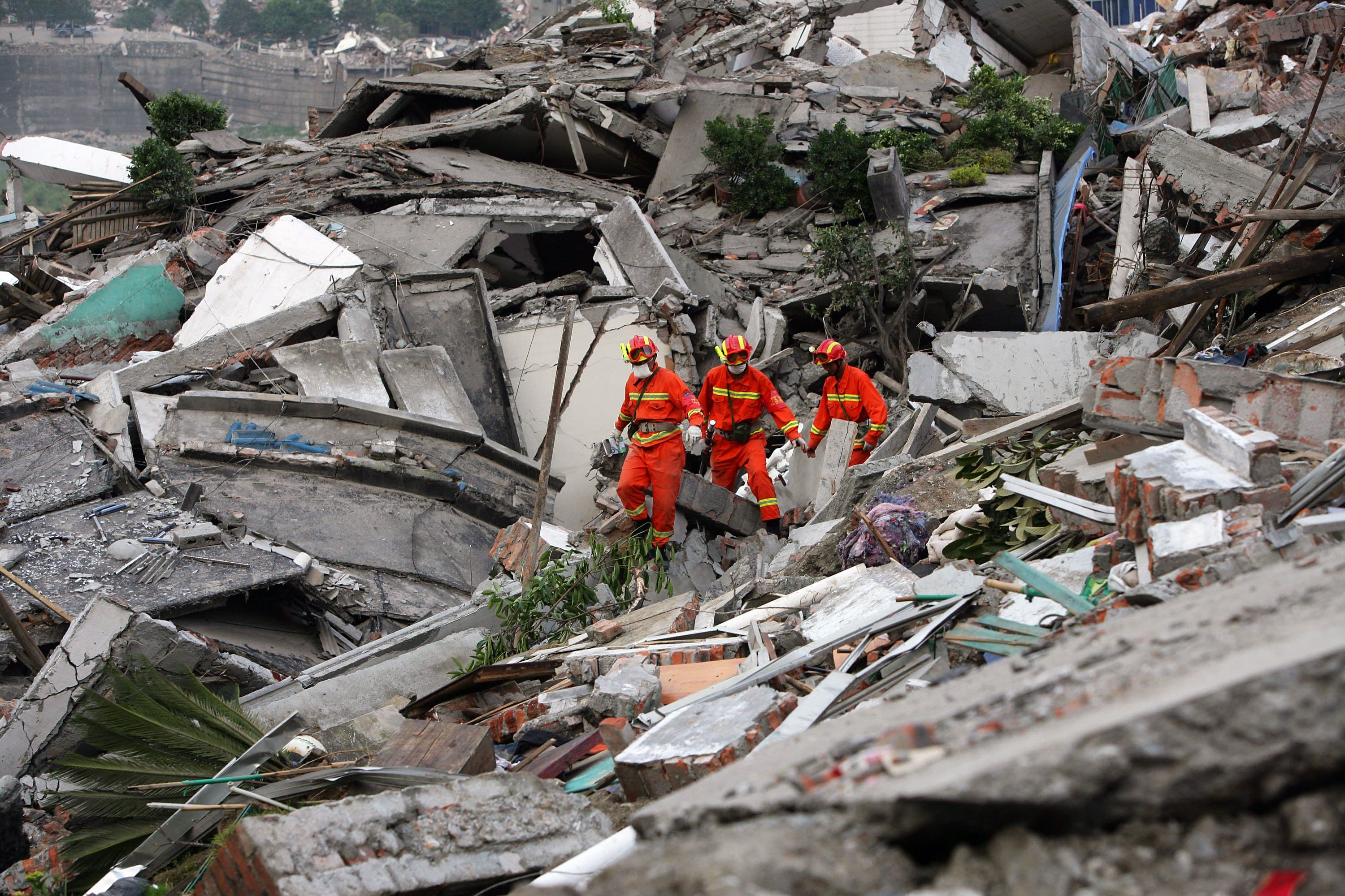 Rescue workers search through the rubble of collapsed buildings in Sichuan Province, days after the magnitude 7.9 earthquake struck Wenchuan County on 12 May 2008.