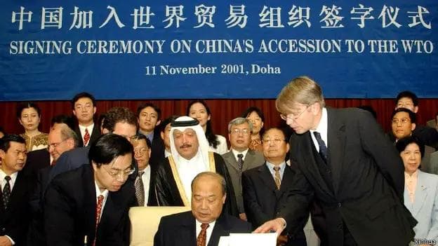 Shi Guangsheng, Minister of Foreign Trade and Economic Cooperation, signs accession documents on behalf of the People's Republic of China at the WTO Signing Ceremony in Doha, Qatar, 11 November 2001. China formally became the 143rd member of the World Trade Organization thirty days later, on 11 December 2001.(Xinhua)