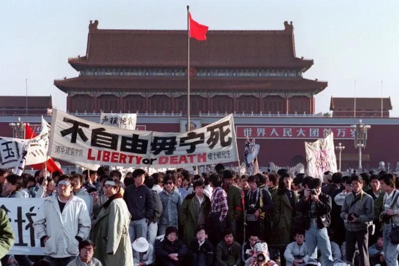 Students from Tsinghua University's School of Architecture carry a banner reading "Liberty or Death" in Tiananmen Square, rallying in support of the hunger strikers. Tiananmen Gate stands in the background. Beijing, May 1989.