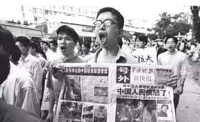 Protesters hold up a newspaper extra edition bearing the headline "The Chinese People Are Furious" during demonstrations that erupted across China following the NATO bombing of the Chinese Embassy in Belgrade, May 1999.
