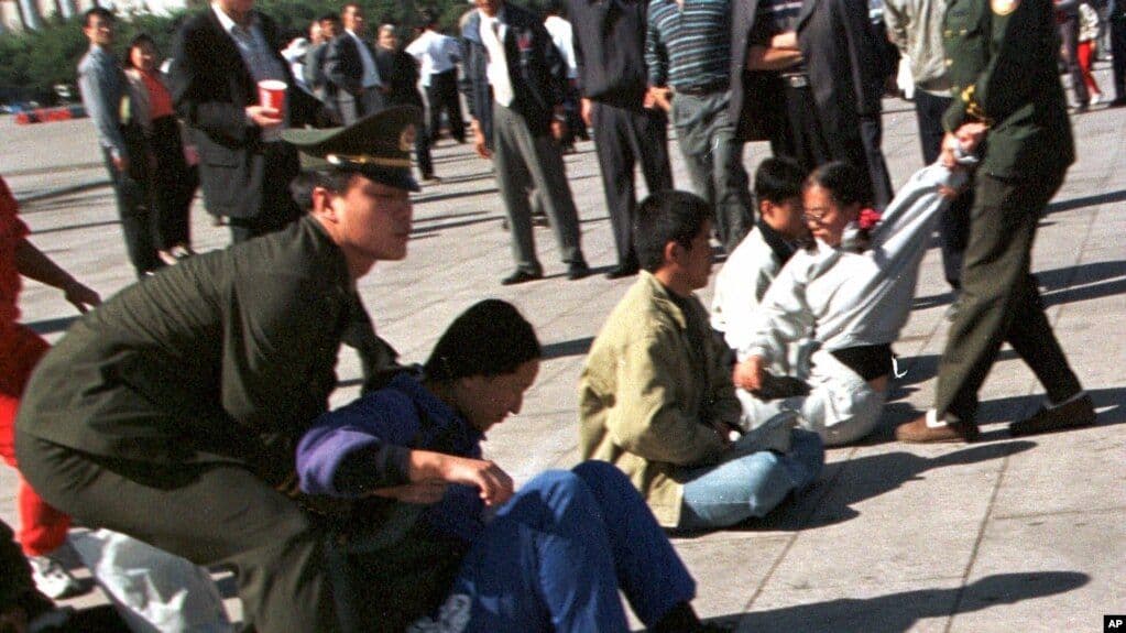 Chinese police officers drag Falun Gong practitioners from Tiananmen Square, Beijing, during the government's suppression campaign against the movement, c. 1999–2001. (AP)